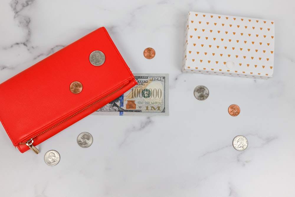 a red wallet and coins