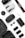 A collection of photography and drone equipment neatly arranged on a white surface. There is a camera lens, a drone, a camera strap with the Canon logo, several batteries, a battery charger, and memory cards. The black and white color scheme gives it a professional and sleek appearance.