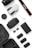 A collection of photography and drone equipment neatly arranged on a white surface. There is a camera lens, a drone, a camera strap with the Canon logo, several batteries, a battery charger, and memory cards. The black and white color scheme gives it a professional and sleek appearance.