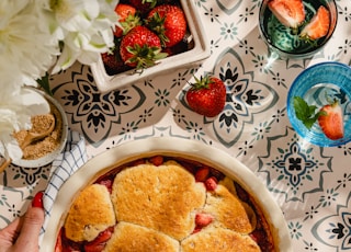 Strawberry Cobbler with vanilla ice cream on blue tile background, summer desserts