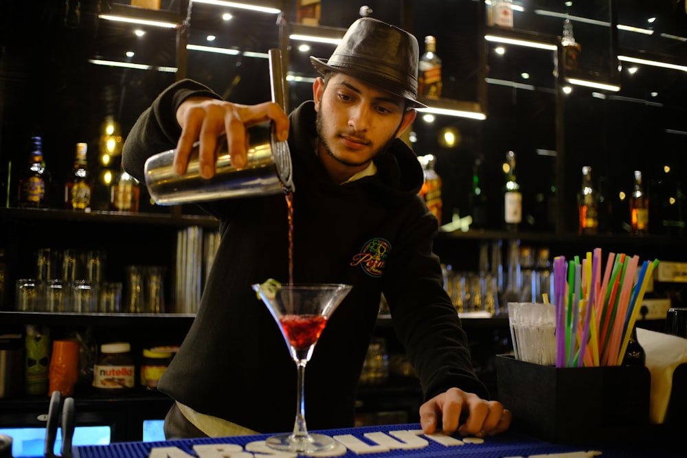 a person in a hat behind a bar