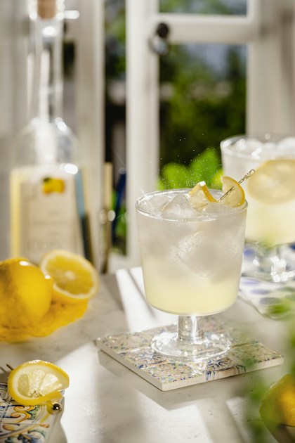 Limoncello spritz jaune pétillant sur glace entouré de citrons frais