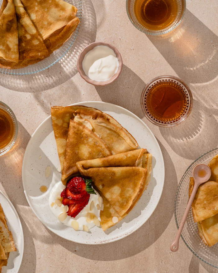 Crêpes aux fraises et yaourt, cuites sur un billig en fonte