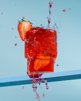 Bright, dynamic splash of natural ingredients like ginseng and berries swirling in water