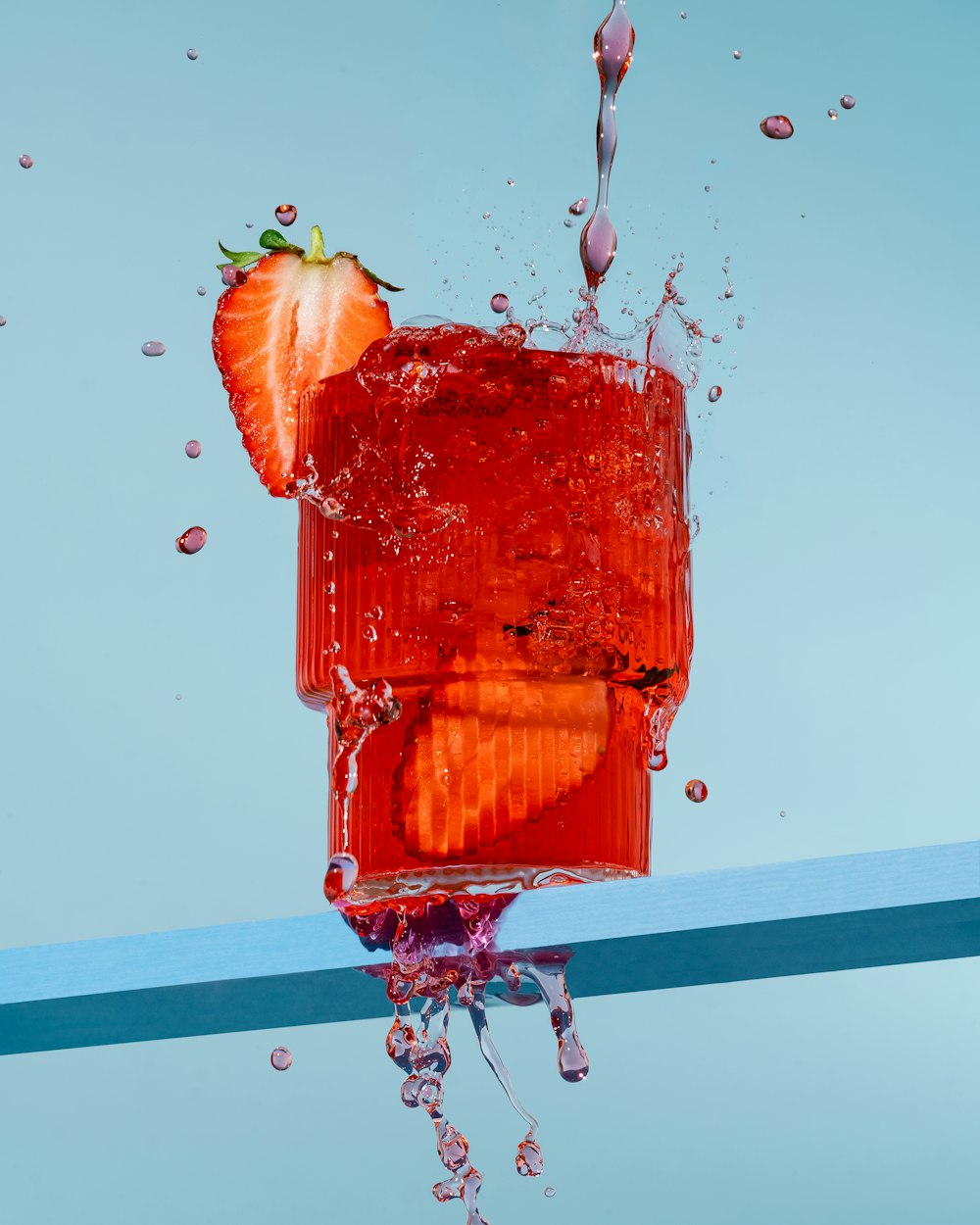 a strawberry splashing into water