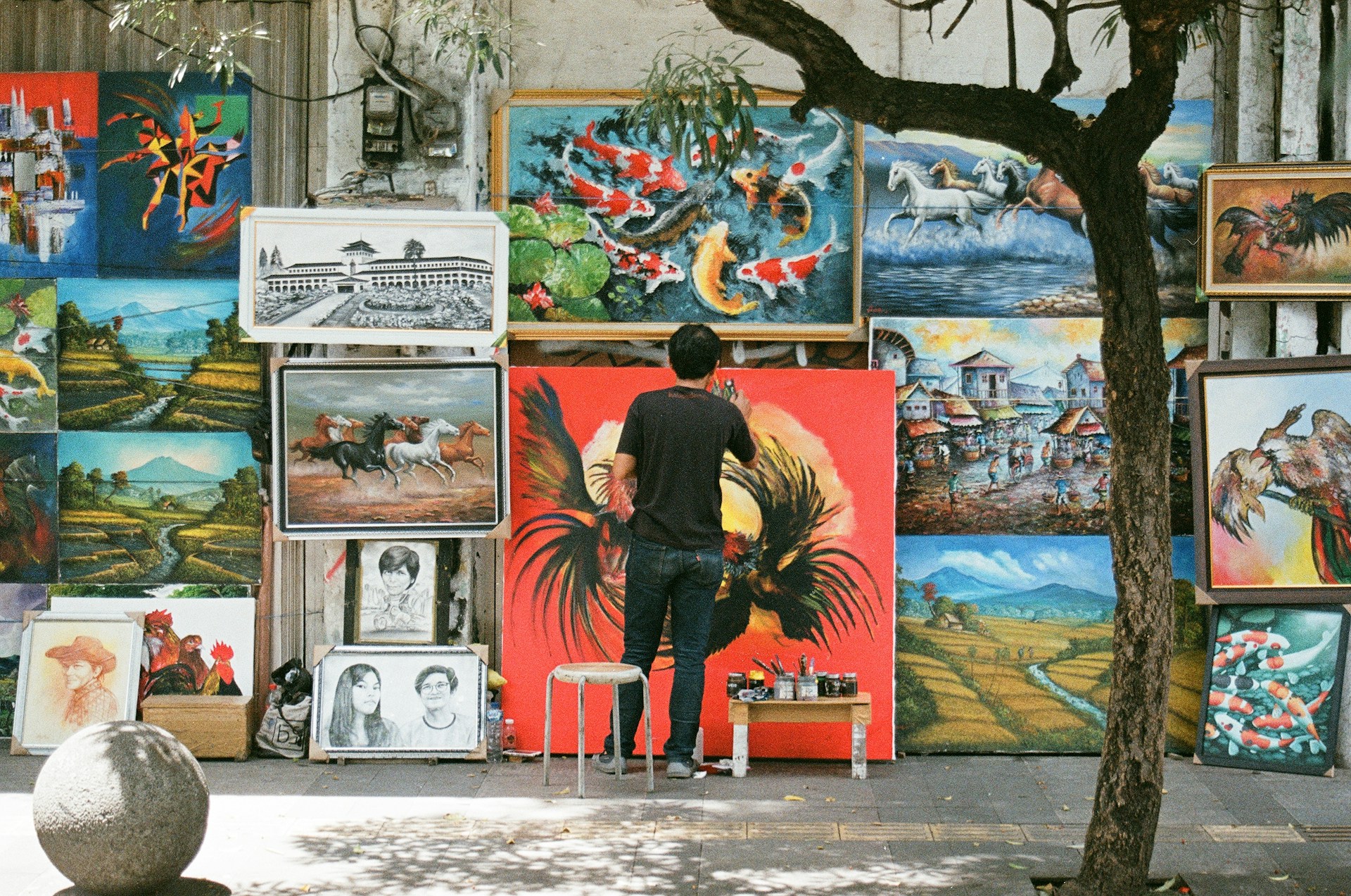 a person standing in front of a wall of paintings