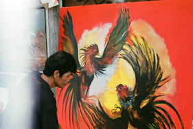 a man and woman looking at a painting on a wall