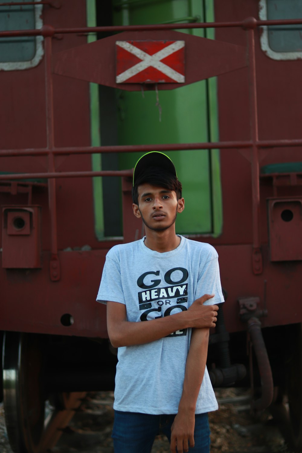 a boy standing in front of a red building with a sign on it