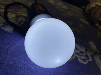 Close-up of a sleek Ryolite rechargeable flashlight glowing warmly in a dim room.