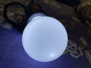 Close-up of a sleek ryolite LED flashlight glowing softly in a dark room