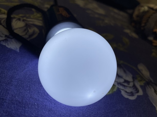 A close-up of a flashlight resting on a wooden table with a soft glow.