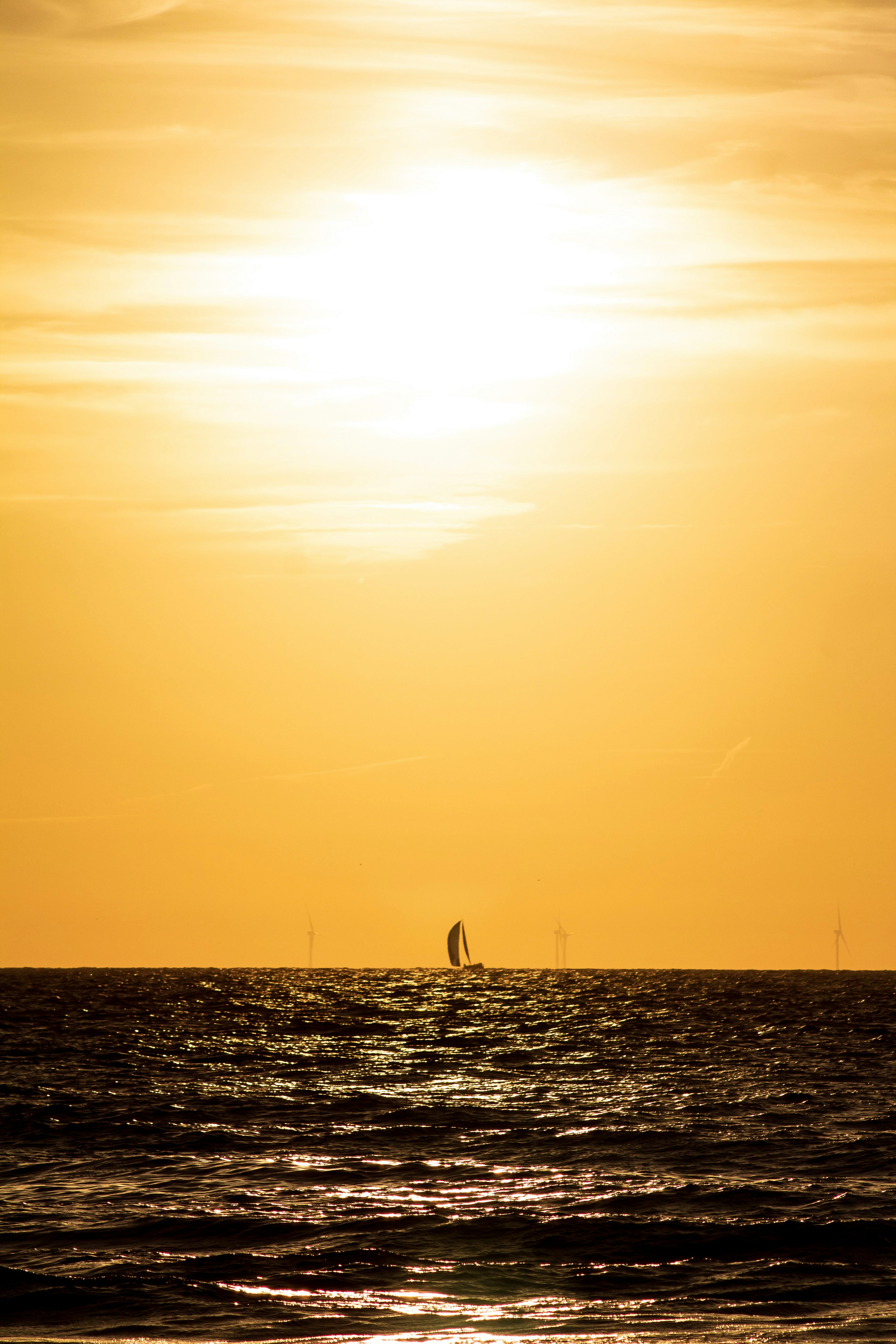 um corpo de água com barcos nele e o sol no céu
