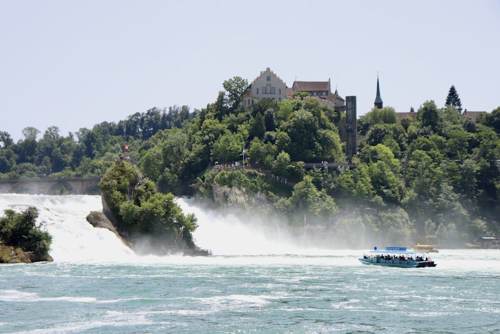 a boat on the water with Rhine Falls in the background