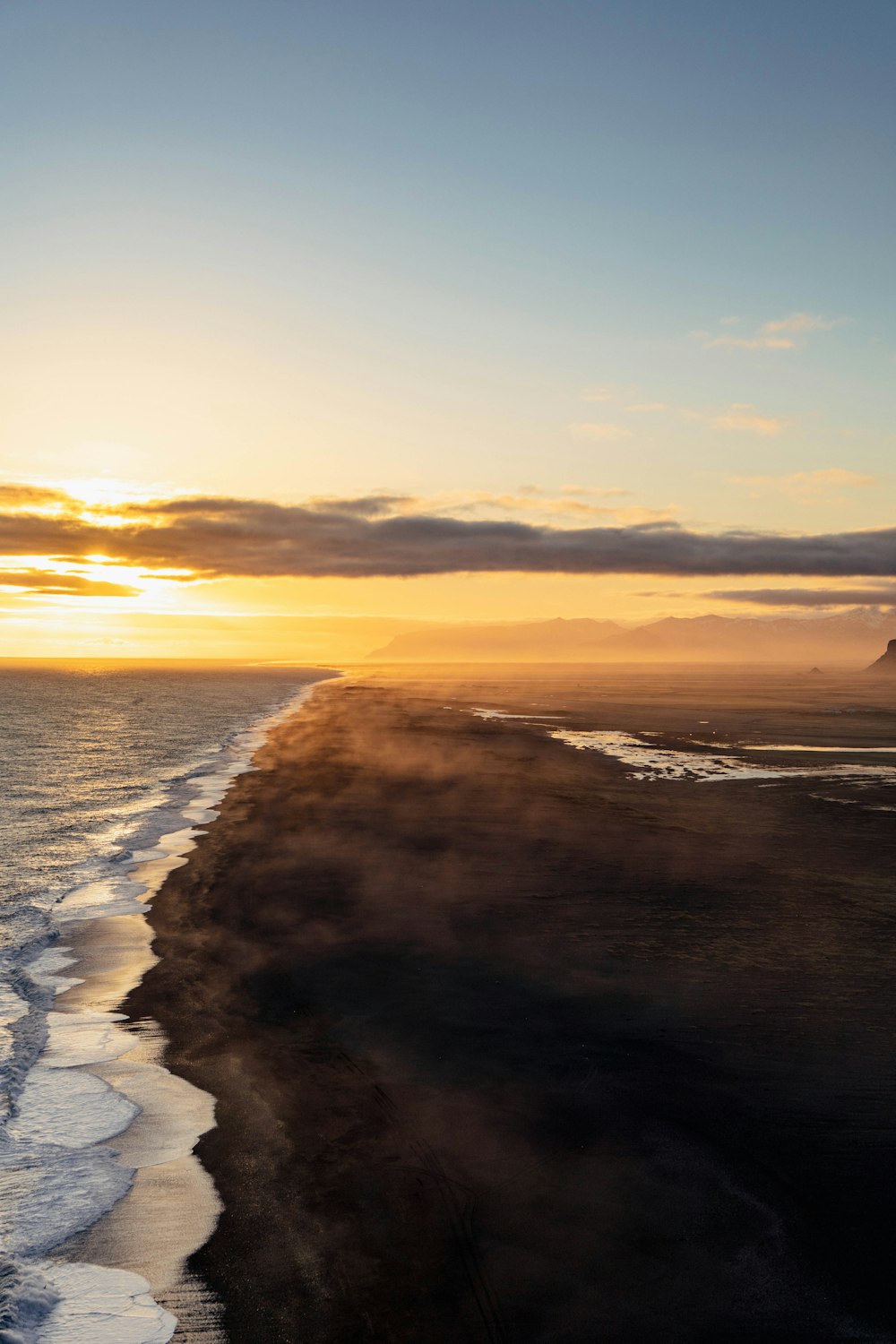 a beach with waves and a sunset