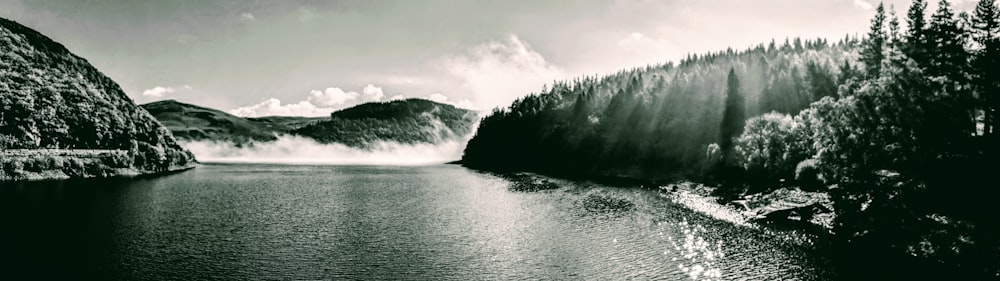 a body of water with trees and mountains in the background