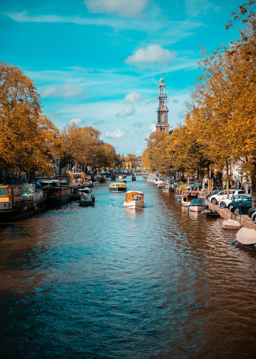 a river with boats on it and trees on the side