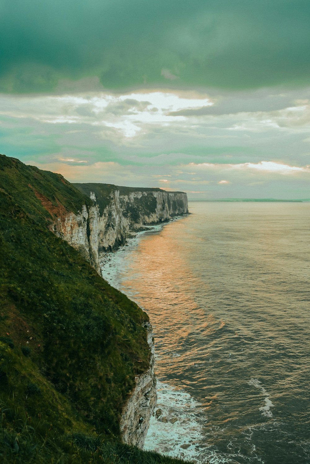 a cliff side with a body of water below