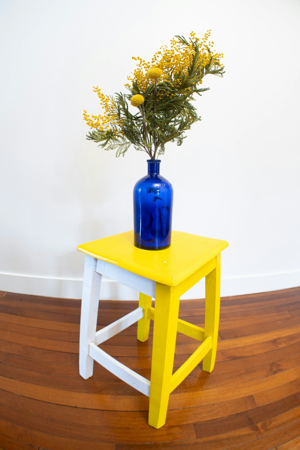 eine Vase mit gelben Blumen auf einem Tisch