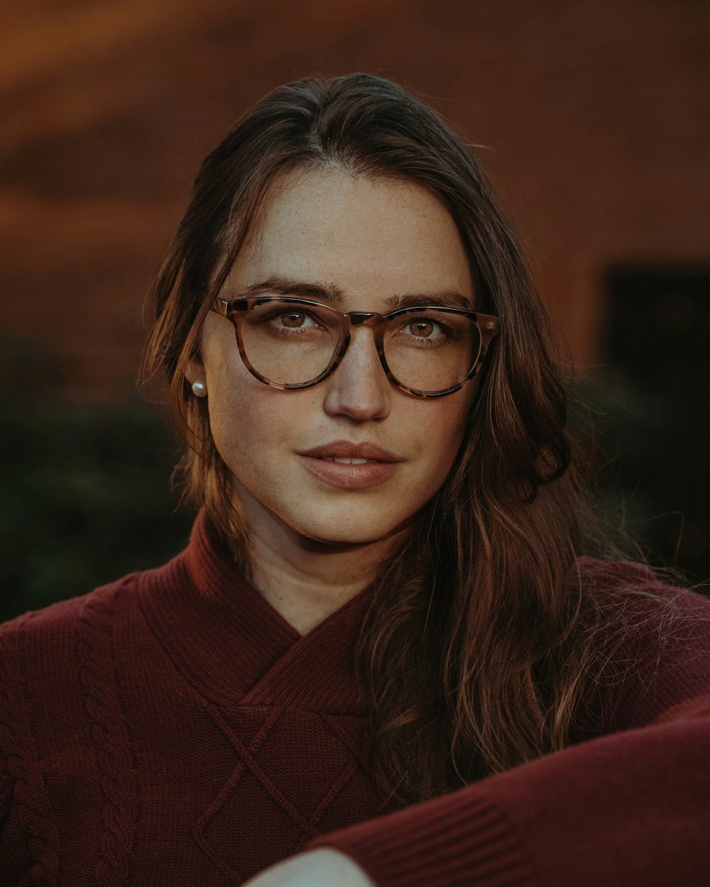 une personne portant des lunettes regardant la caméra