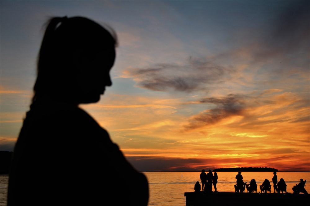 a silhouette of a person looking at the sunset