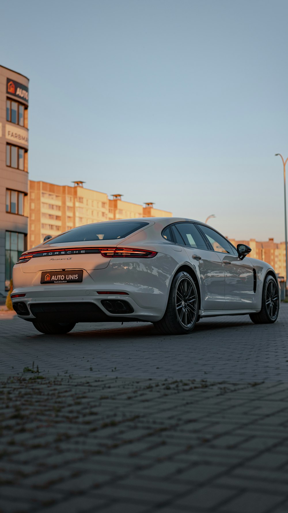 a silver sports car parked on a brick road