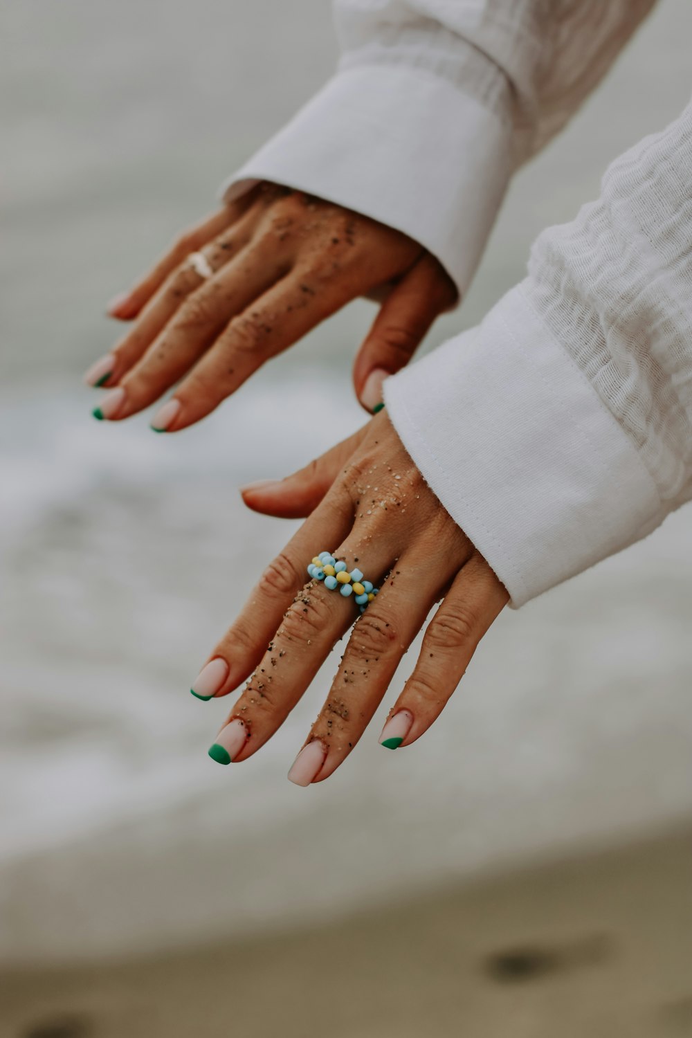 a person's hands holding a small green object