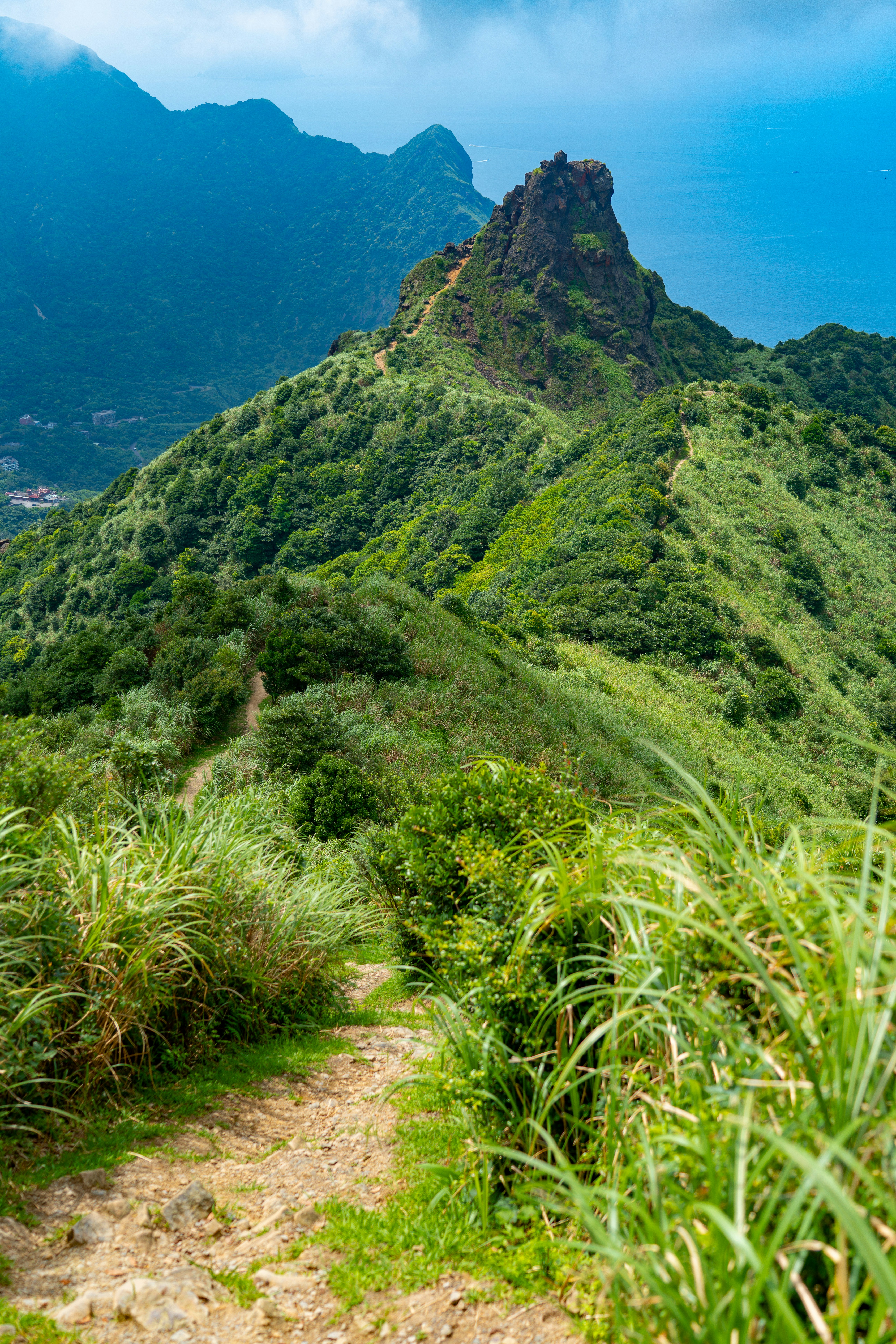 a dirt path leading to a mountain