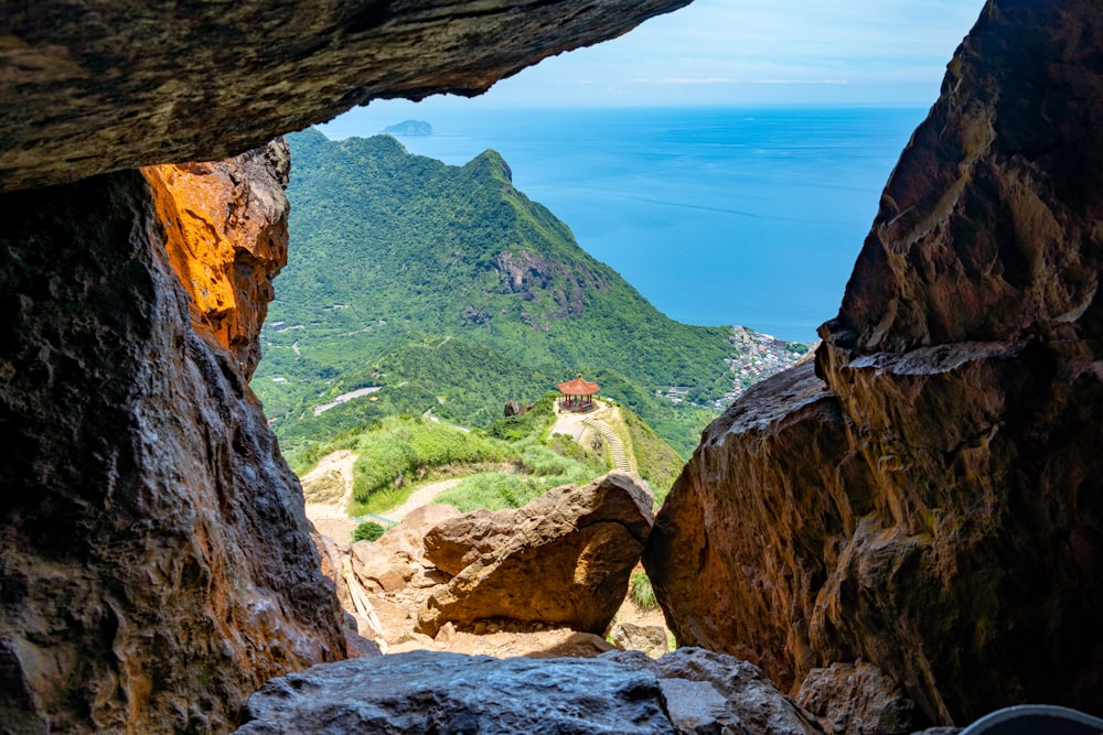 a view of a building through a cave in a cliff