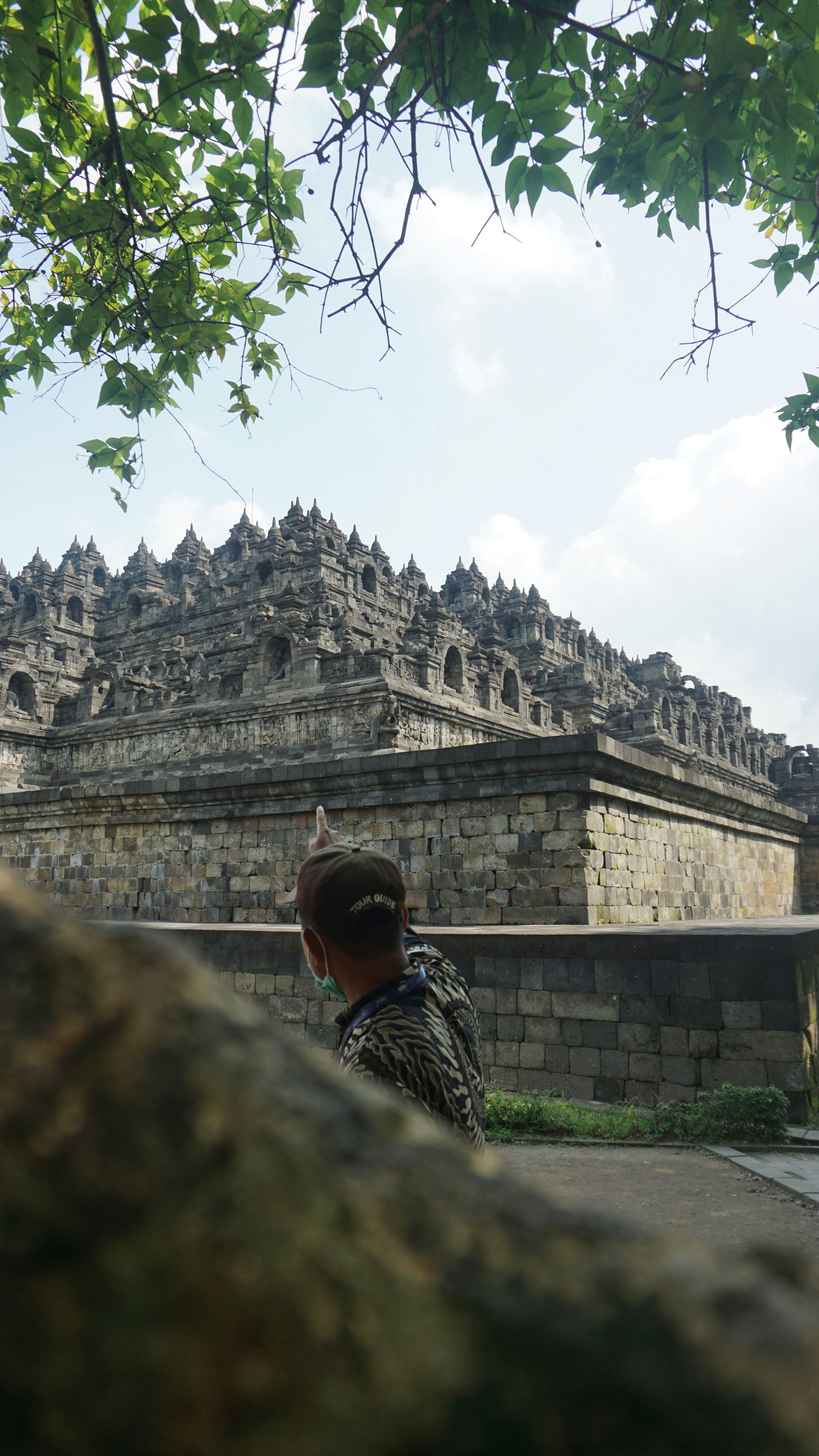 A man standing in front of a stone building photo – Free Temple Image ...