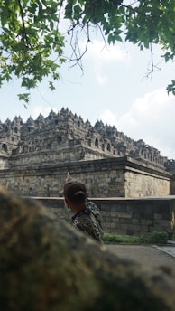 a man standing in front of a stone building