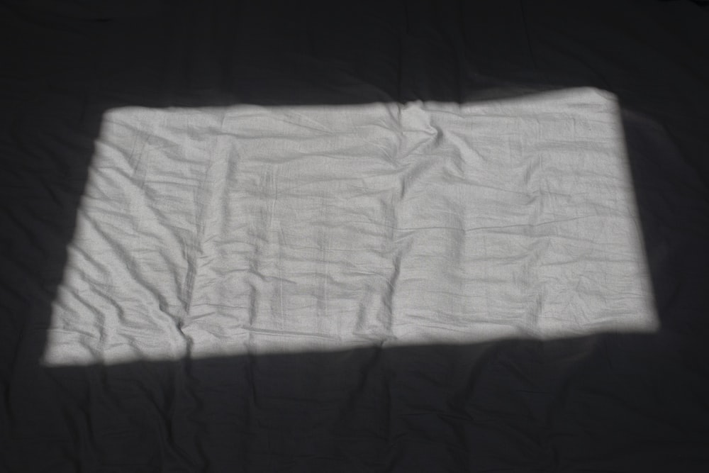 a white pillow on a black surface