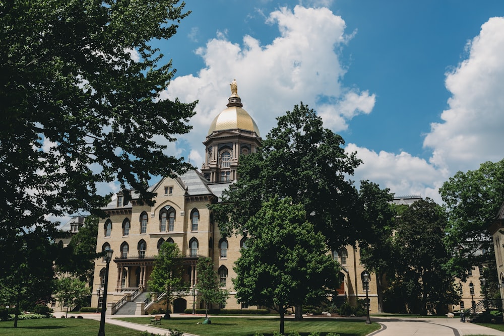 a large building with a dome and trees in front of it