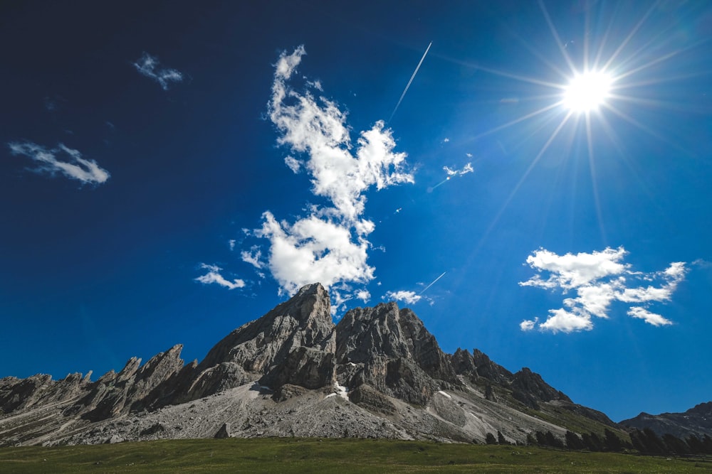 a mountain with a blue sky and clouds