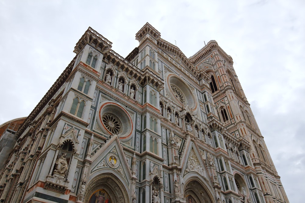 ein großes Gebäude mit einer Uhr darauf mit der Kathedrale von Florenz im Hintergrund