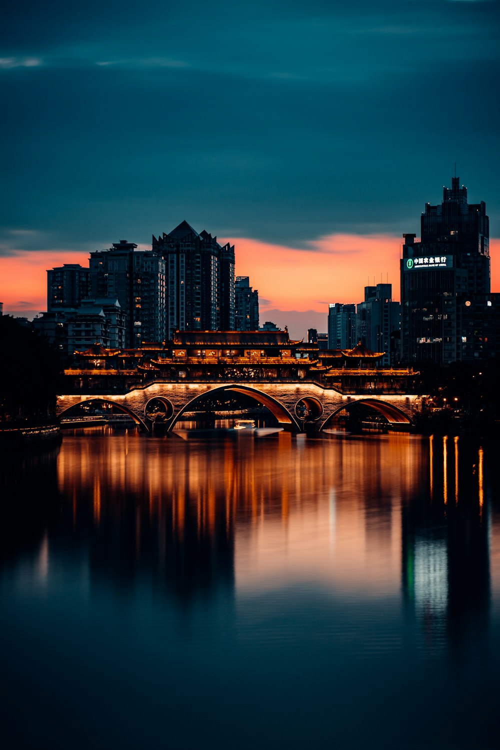 a bridge over a river with a city in the background