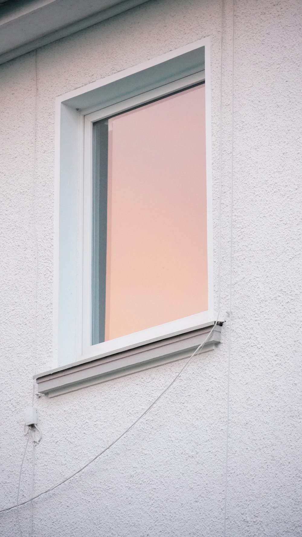 a window with a pink curtain