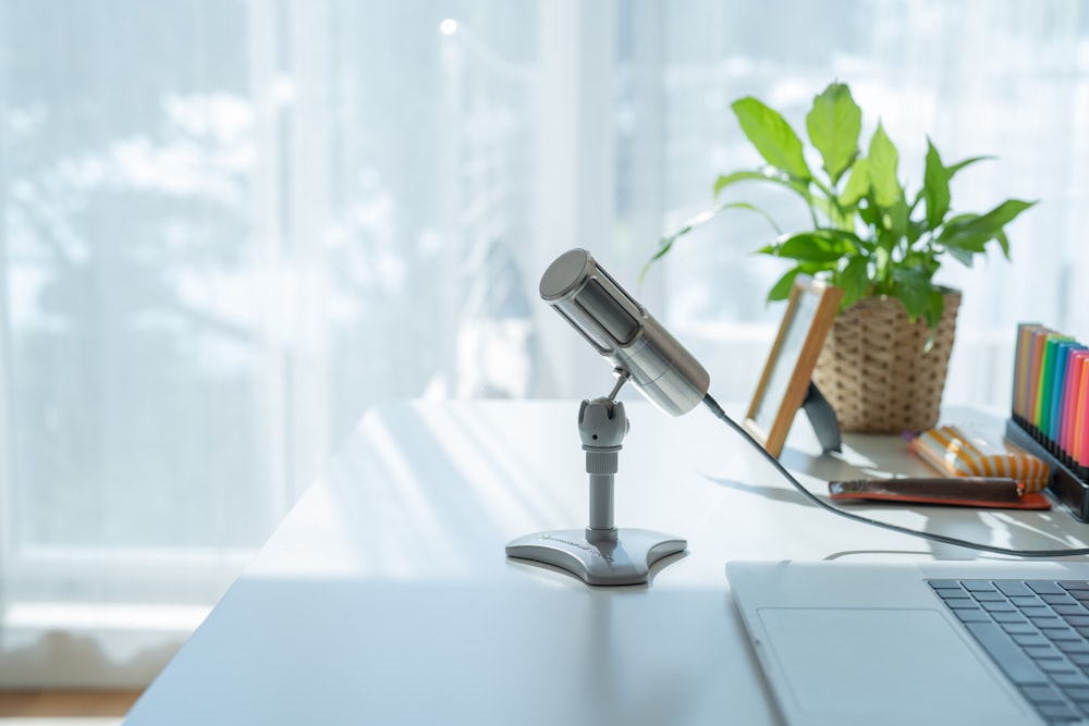 a desk with a laptop and a lamp on it