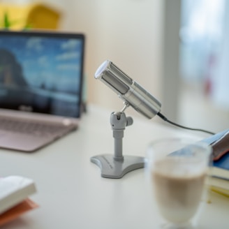 a desk with a computer and a glass of water