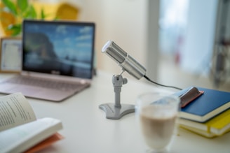 a desk with a computer and a glass of water