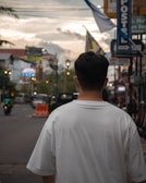 A sunlit scene showing a person wearing a relaxed-fit shirt walking in the city.
