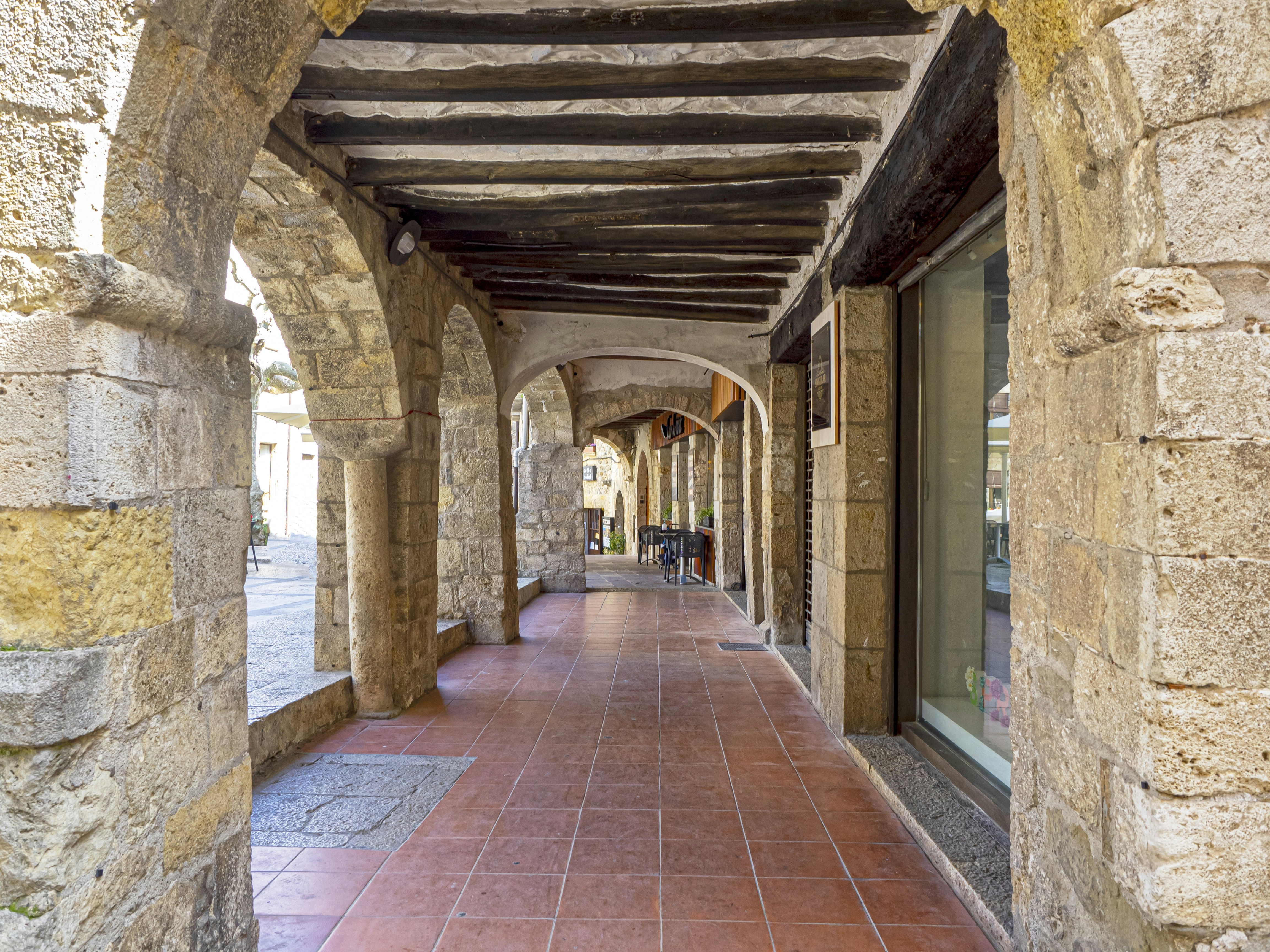 Fotomural a brick walkway with stone walls
