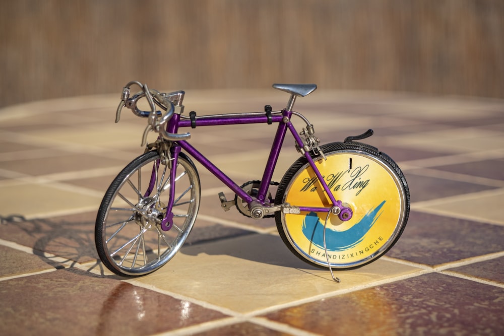 a purple bike with yellow and blue wheels