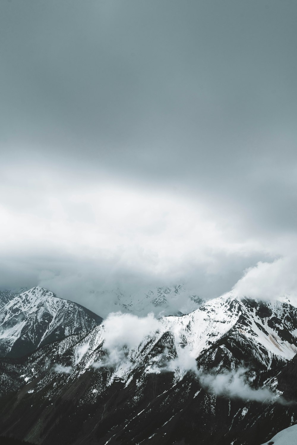 a snowy mountain with clouds