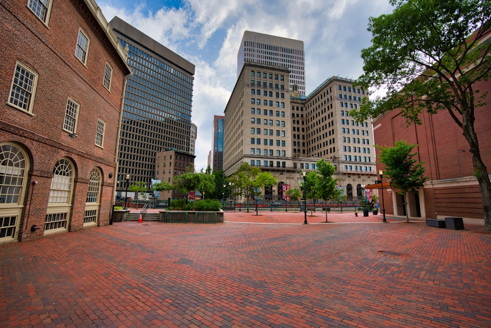 a brick courtyard with buildings in the background