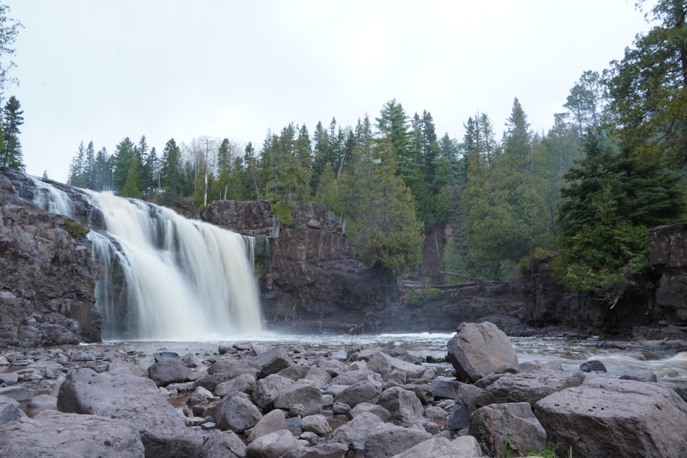 Una cascada con árboles al fondo