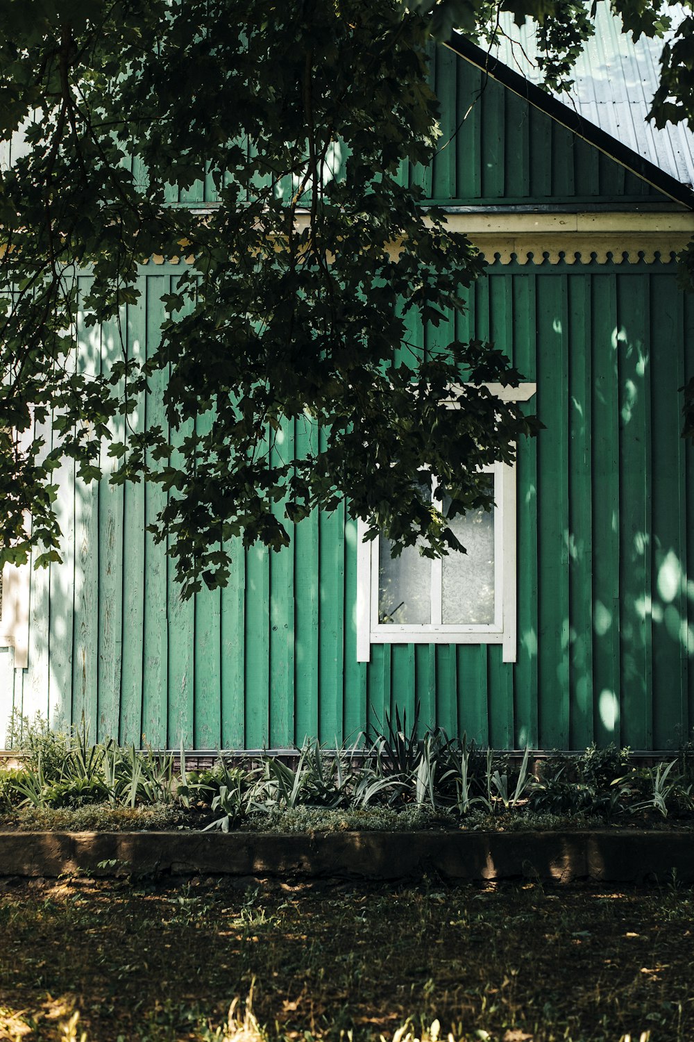 a green fence with a white window