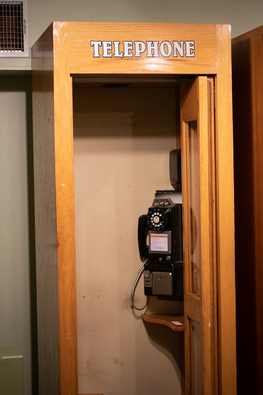 a telephone in a wooden cabinet