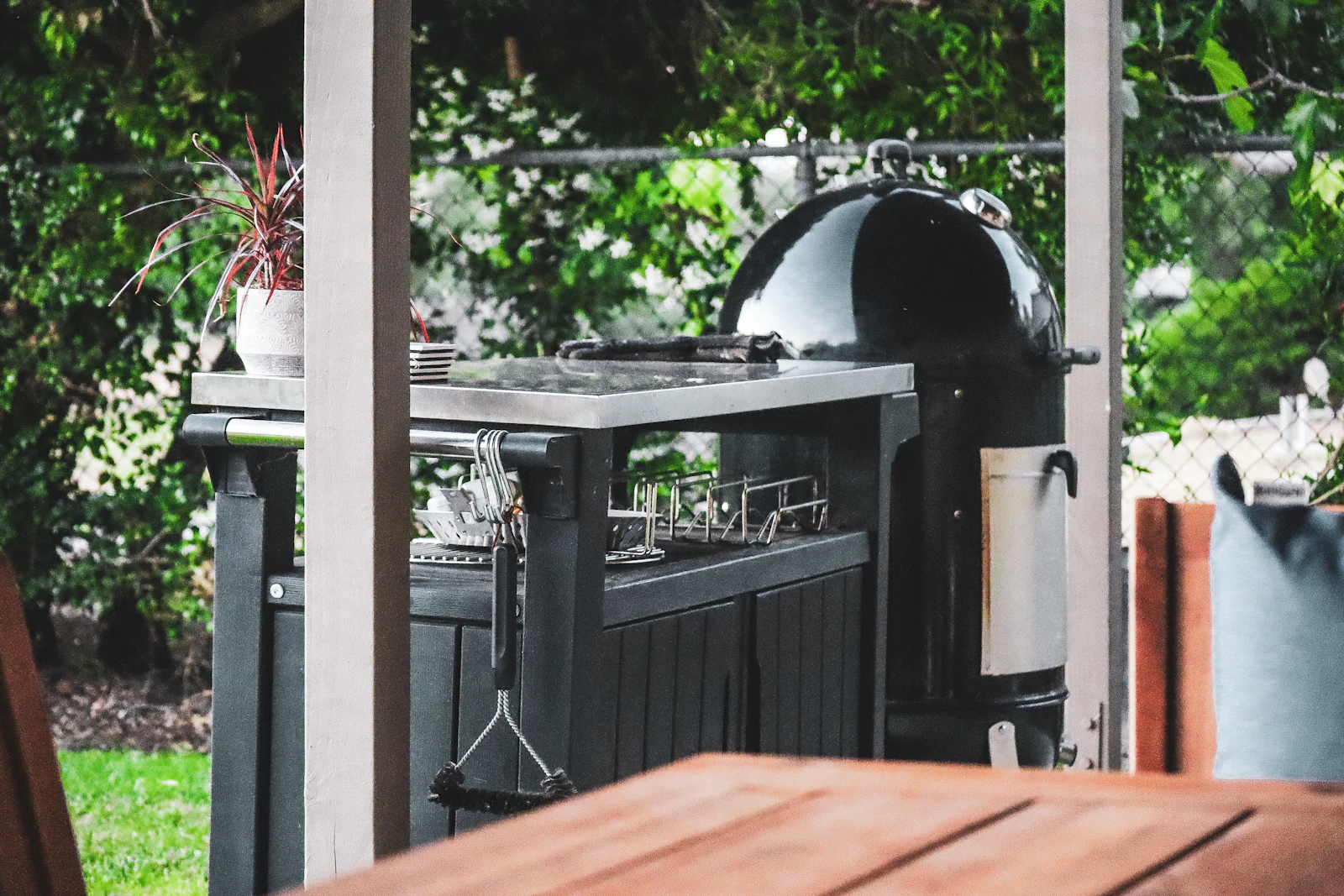 Outdoor cooking station with grill and prep counter in a backyard