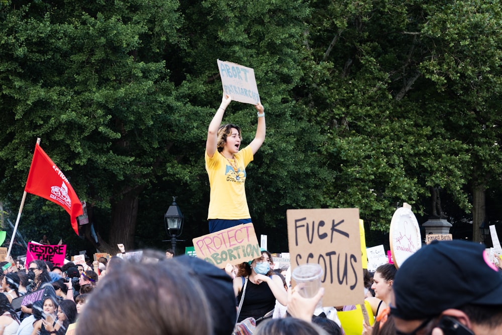 a man holding a sign in front of a crowd of people