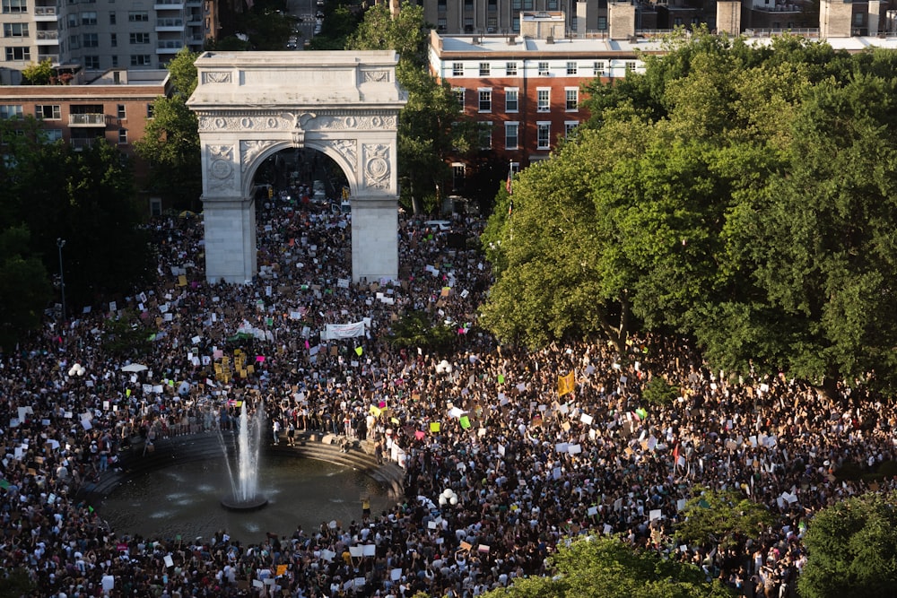 a large crowd of people in front of a large stone structure